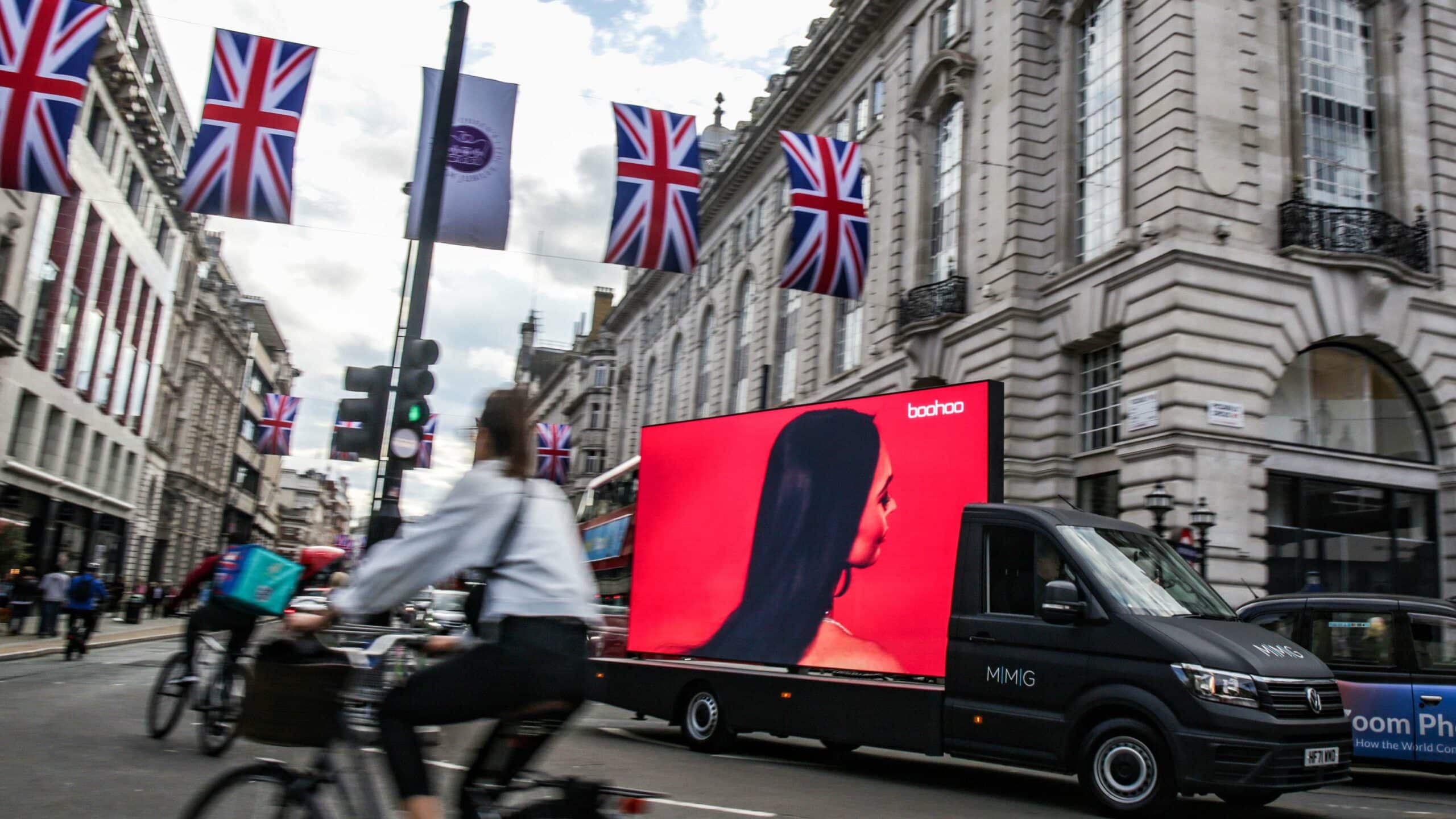 Person on a bike going past red digital screen